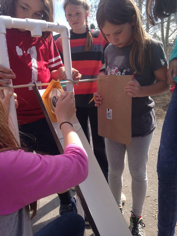 Students measuring the angle of a miniature landslide flume