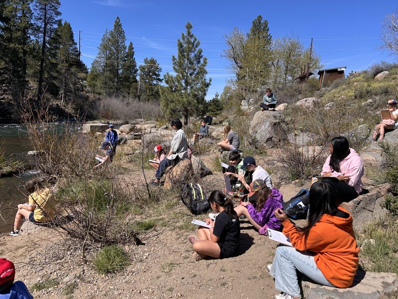Students nature-journaling on the bank of the Truckee River